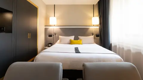 Chambre de l'Hôtel Roosevelt, tête de lit et coussins jaunes
