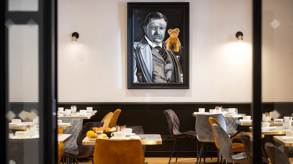 Salle du petit-déjeuner de l'Hôtel Roosevelt, portrait encadré et banquettes sombres